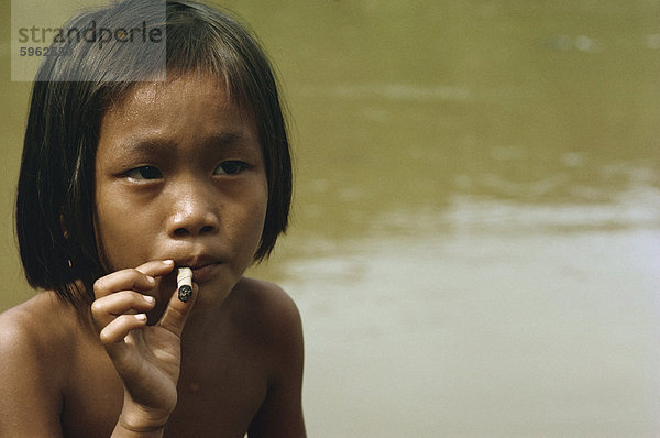 Kayan Kind Rauchen  entlang des Balui River  Sarawak  Malaysia  Südostasien  Asiens