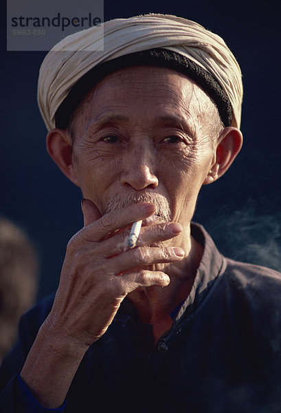 Mann mit traditionellen weißen Kopfschmuck  Sichuan  China  Asien