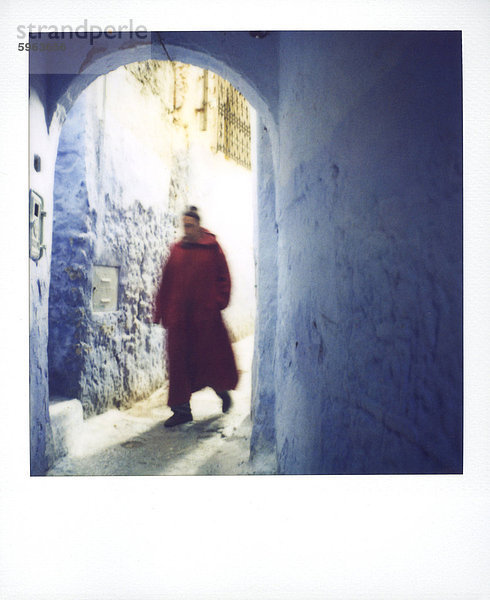 Polaroid des Mannes tragen rote Djellaba Wandern durch Bluewashed Torbogen  Chefchaouen  Marokko  Nordafrika  Afrika