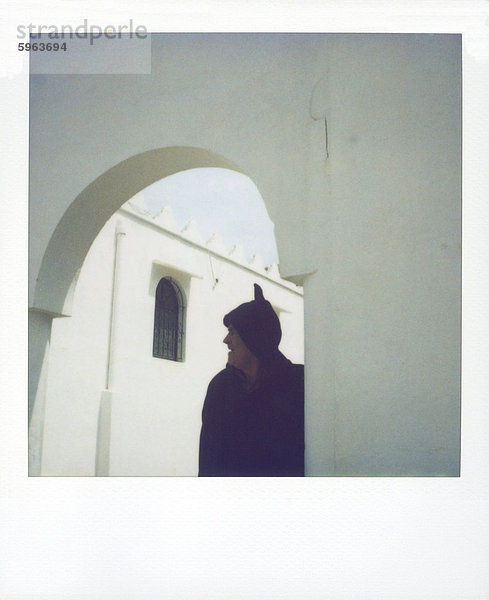 Polaroid Bild des Mannes tragen traditionelle wollene Djellaba in Semi-silhouette unter weiß getünchten Torbogen  Chefchaouen  Marokko  Nordafrika  Afrika