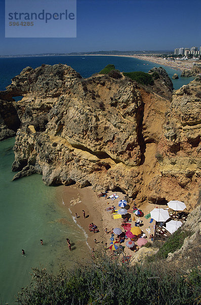 Luftbild von Touristen auf einem kleinen Strand oder Bucht an der felsigen Küste Praia de Rocha in der Algarve  Portugal  Europa