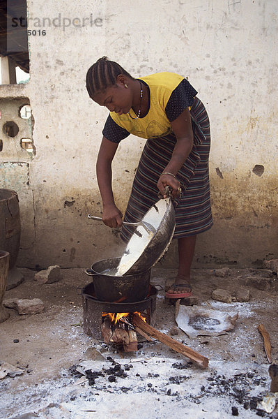 Porträt einer Frau  die Kochen im freien über ein kleines Feuer  Gambia  Westafrika  Afrika