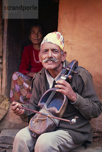 Porträt eines Mannes von Gaines  Kaste der Musiker  ein Saiteninstrument spielen und der Kamera  in Pokhara  Nepal  Asien