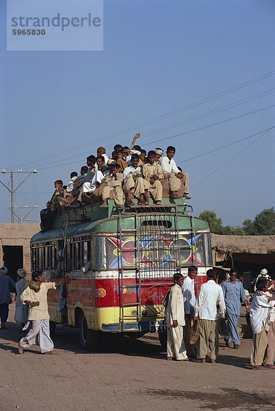 Überladene Bus mit Männer Reiten auf dem Dach in der Nähe von Multan in Pakistan  Asien