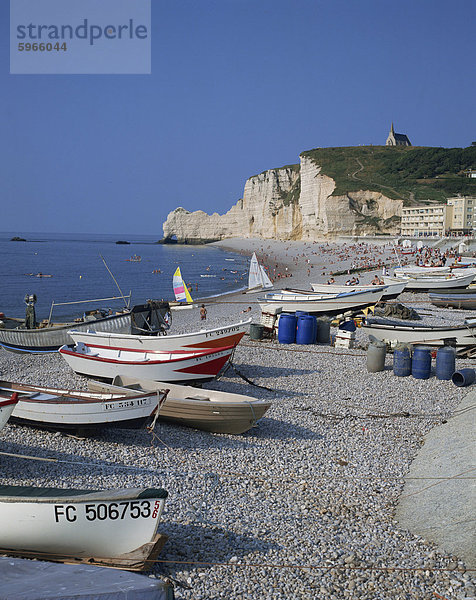 Kleine Boote und Menschen am Strand mit Felsen im Hintergrund bei Etretat  auf der Küste von Haute-Normandie  Frankreich  Frankreich