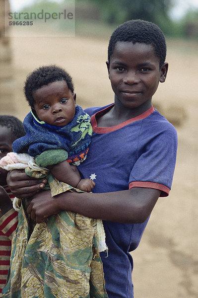 Mädchen halten Baby  in der Nähe von Masaka  Uganda  Ostafrika  Afrika