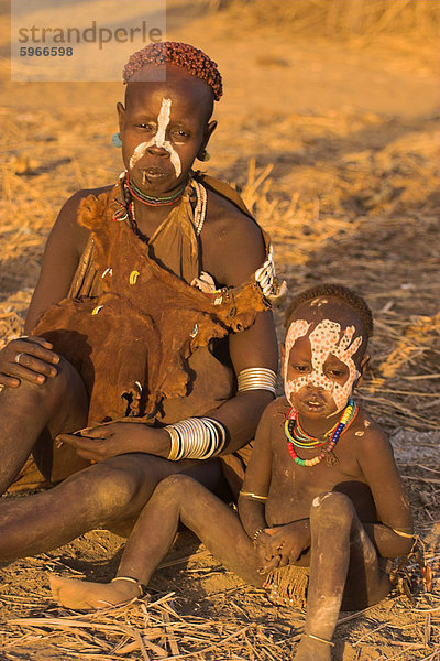 Karo-Frau mit Kind  die traditionelle Ziegenfell Kleid verziert mit Kaurimuscheln  Kolcho Dorf  unteren Omo-Tal  Äthiopien  Afrika