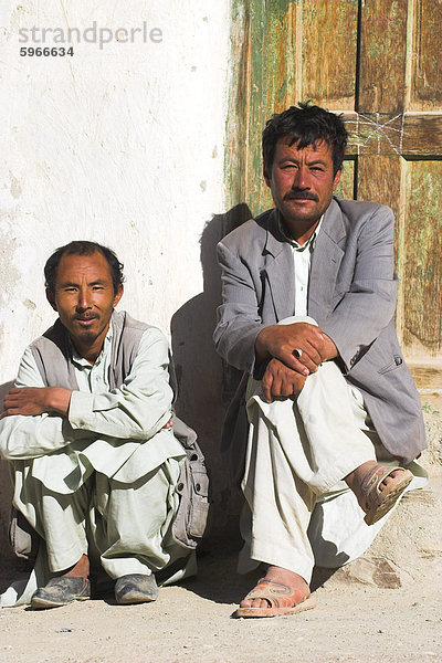 Zwei Männer sitzen vor einer Tür  Syadara  zwischen Yakawlang und Daulitiar  Afghanistan  Asien