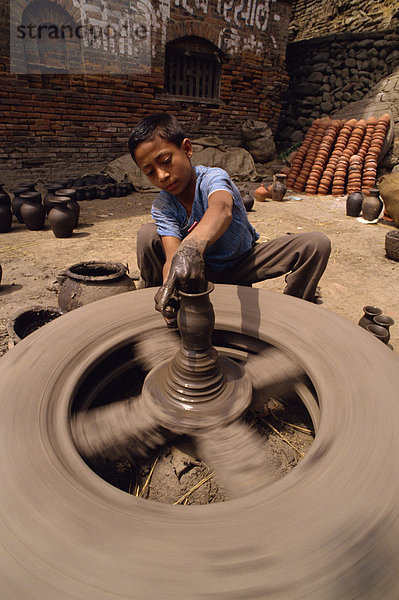 Junge werfen ein Topf  Potters Square  Bhaktapur  Nepal  Asien