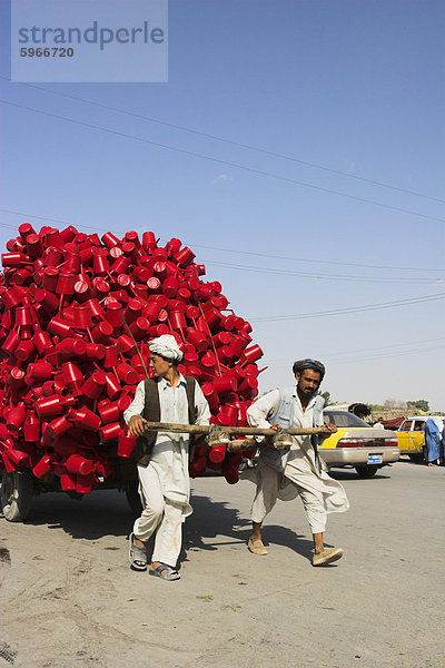 Männer ziehen hölzerne Karre Langhaar High mit roten Wasserbehältern entlang Road  Mazar-I-Sharif  Balkh Provinz  Afghanistan  Asien