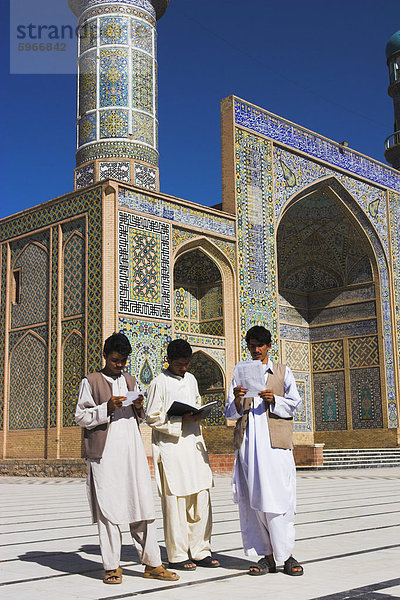 Männer lesen vor der Freitagsmoschee oder Masjet-eJam  gebaut im Jahr 1200 durch die Ghorid Sultan Ghiyasyddin auf dem Gelände einer früheren 10. Jahrhundert Moschee  Herat  Provinz Herat  Afghanistan  Asien