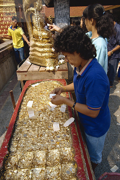 Frau mit Goldfolie  Wat Phra  dass Doi Suthep  Chiang Mai  Thailand  Südostasien  Asien