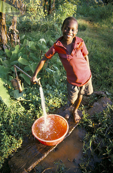 Knabe am Wasser klopfen  Chuka Village  Mount Kenia  Kenia  Ostafrika  Afrika