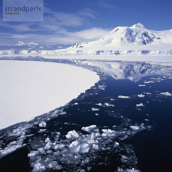 Reflexionen im eisigen Meer Schnee bedeckt Berg  an der Westküste der Antarktischen Halbinsel  Antarktis  Polarregionen