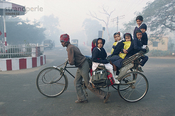 Schulkinder fahren in einer Rikscha in Agra  Uttar Pradesh  Indien  Asien