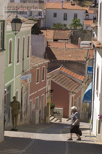 Eine ältere Frau geht über die Straße in Monchique  Algarve  Portugal  Europa