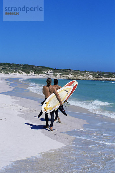 Zwei Surfer gehen mit ihren Boards auf Kommetjie Strand  Kapstadt  Südafrika  Afrika