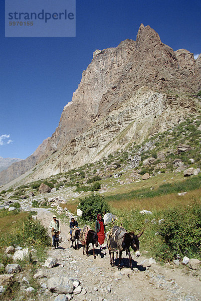 Familie und Eseln auf einer rauen Straße im Serawschan-Gebirge in der Nähe von Ayni  Tadschikistan  Zentralasien  Asien