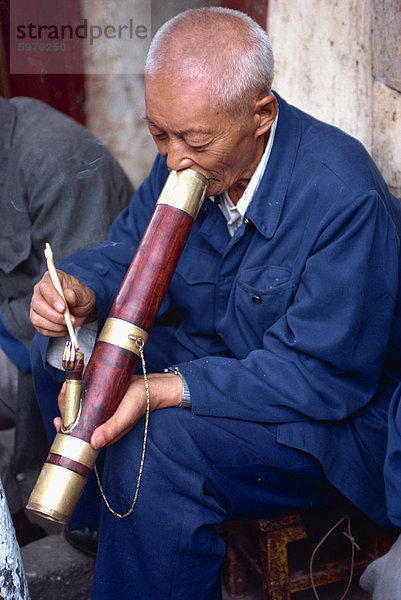 Porträt eines Mannes Rauchen ein langes Rohr in einem Teehaus in Kunming  China  Asien