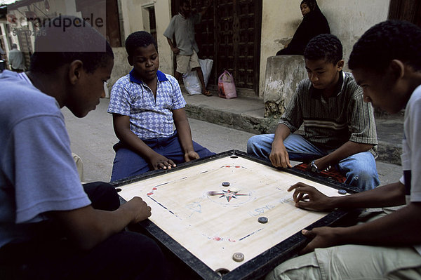 Einheimischen spielen ein Brettspiel in den Straßen von Stone Town  Sansibar  Tansania  Ostafrika  Afrika