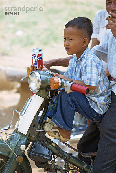 Porträt eines kleinen Jungen mit eine Dose Pepsi  auf einem Motorrad in Phnom Penh  Kambodscha  Indochina  Südostasien  Asien