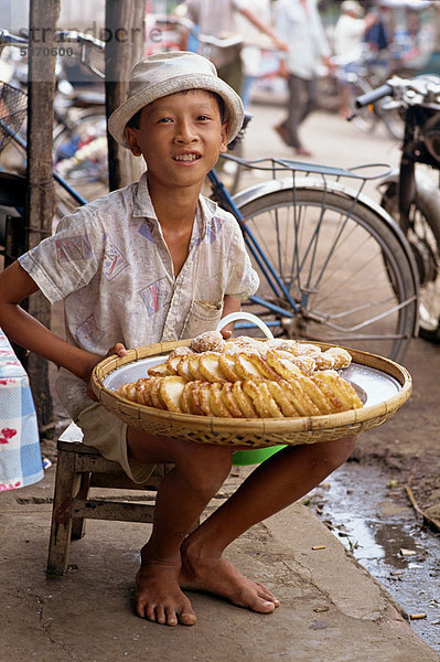 Bildnis eines Knaben verkaufen süße Kuchen auf dem Bürgersteig in der Stadt von Rach Gia in das Mekong-Delta  Vietnam  Indochina  Südostasien  Asien