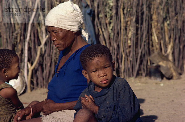 Zwei junge Kinder mit Mutter  Kalahari  Botswana  Afrika