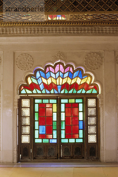 Original alte Glasmalerei in Türen und dekorative Jali Holzschnitzerei in Tür  Mehrangarh Fort  Jodhpur  Rajasthan state  Indien  Asien