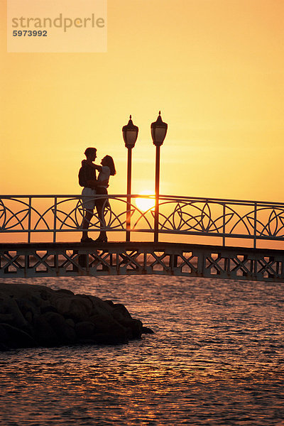 Paar auf Brücke bei Sonnenuntergang  Antillen  Aruba  niederländische Karibik  Zentralamerika