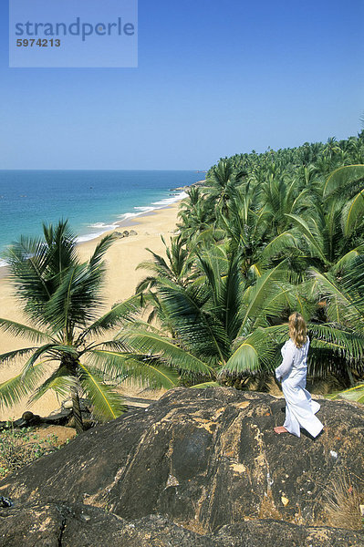 Frau suchen über Kokospalmen an den Strand  Kovalam  Kerala Zustand  Indien  Asien