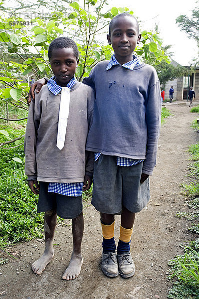 Zwei Schuljungen in Make-do Schuluniform  fixiert man barfuß  mit weißem Baumwollgewebe anstelle Schule Krawatte  Langalanga Primary School  Gilgil Bezirk  Rift Valley in Kenia  Ostafrika  Afrika