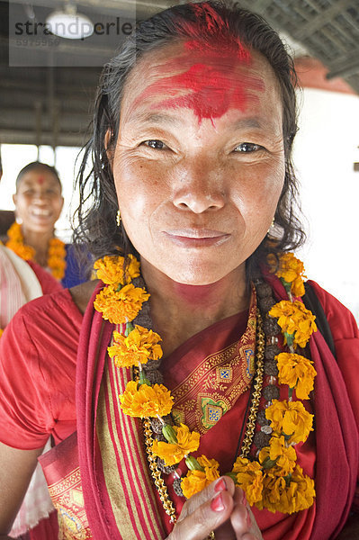 Frau aus Sonapur  östlich von Guwahati  der Shakti (Sun Worship) Sekte  traditionell in rot gekleidet garlanded mit Tempel rot auf Stirn  Kamakhyal Tempel  Guwahati  Assam  Indien  Asien