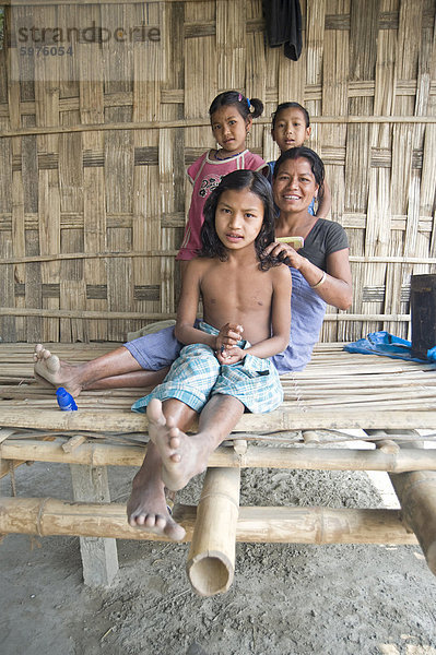 Mishing Tribeswoman Kämmen ihrer Tochter Haare auf der Veranda ihres Hauses  Majuli Island  Assam  Indien  Asien