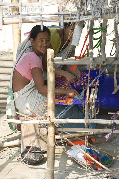 Assamesisch Stammes-Dorffrauen Spinnen Baumwolle am heimischen Webstuhl  Majuli Island  Assam  Indien  Asien