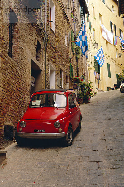 Rotes Auto geparkt in der schmalen Straße  Siena  Toskana  Italien