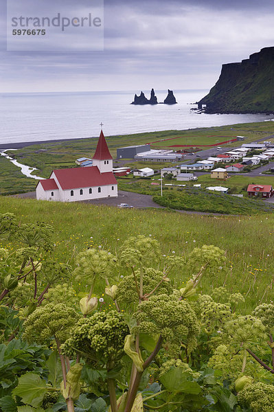 Kirche und Dorf Vik (Vik ein Myrdal) und Reynisdrangar Meer Stacks in der Ferne  Süden der isländischen Küste (Sudurland)  Island  Polarregionen