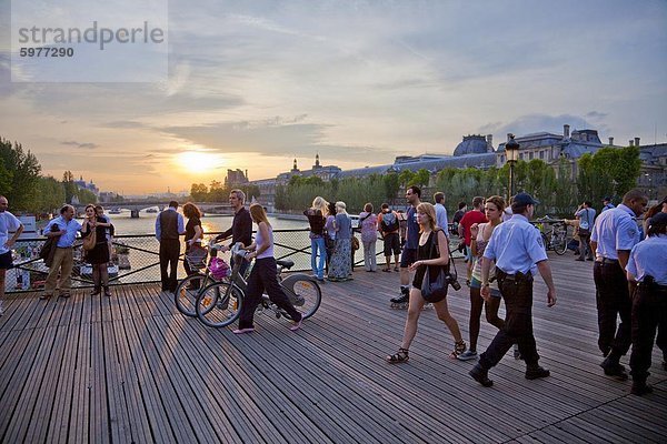 Menschen genießen den Sonnenuntergang  Pont des Arts  Paris  Frankreich  Europa