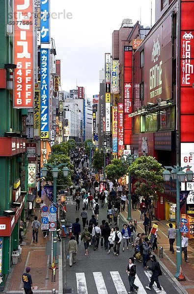 Eine Fußgängerzone  gesäumt von Geschäften und Schilder zieht eine Menge in Shinjuku  Tokio  Japan  Asien