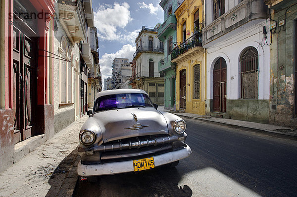 Altes amerikanische Plymouth Auto geparkt auf einsame Straße von alten Gebäuden  Havanna Centro  Havanna  Kuba  Westindische Inseln  Caribbean  Mittelamerika