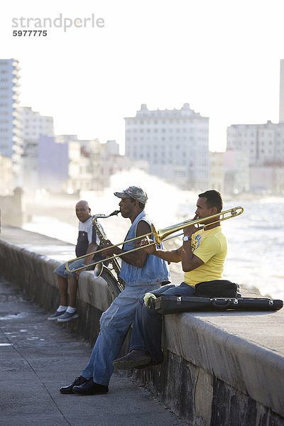 Havanna Hauptstadt Wasserrand Hintergrund Musiker Karibik Westindische Inseln Mittelamerika Kuba Malecon spielen Posaune Wellen brechen