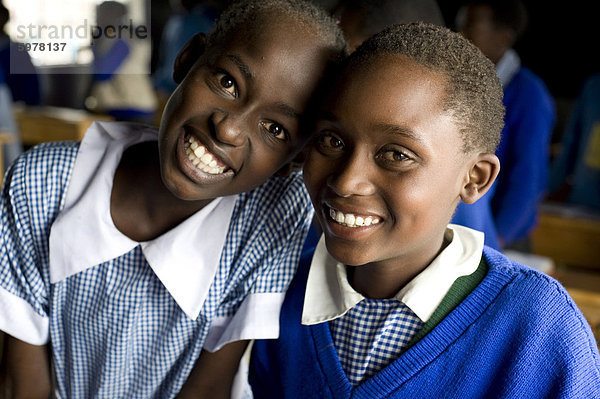 Schulmädchen  zwei Freunde  in Schuluniform und Lächeln  Karunga Primary School  Rift Valley in Kenia  Ostafrika  Afrika  Afrika