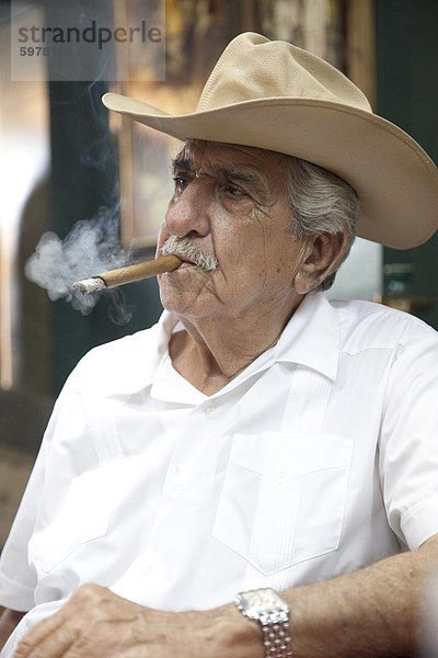 Kubanische Emigranten Rauchende Zigarre trägt einen Cowboy-Hut in Calle Ocho  Miami  Florida  Vereinigte Staaten von Amerika  Nordamerika