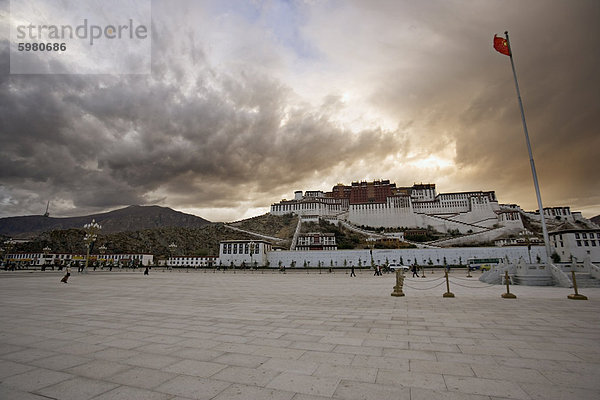 Die rote Fahne China fliegen im Potala Platz an einem stürmischen Nachmittag vor dem Potala-Palast  UNESCO-Weltkulturerbe  Lhasa  Tibet  China  Asien