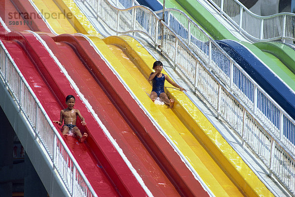 Kinder auf der Wasserrutsche von Big Splash Aquatic Disneyland  Parkway Parade in Singapur  Südostasien  Asien