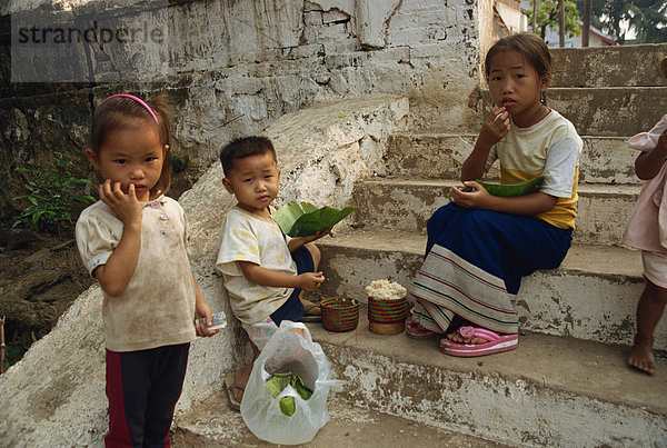 Kinder sitzen auf Schritte und Essen aus Blatt Platten in Luang Prabang  Laos  Indochina  Südostasien  Asien