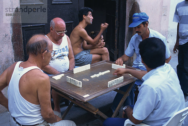 Eine Gruppe von Männern spielen Dominosteine im Freien in alten Havanna  Kuba  Westindische Inseln  Mittelamerika