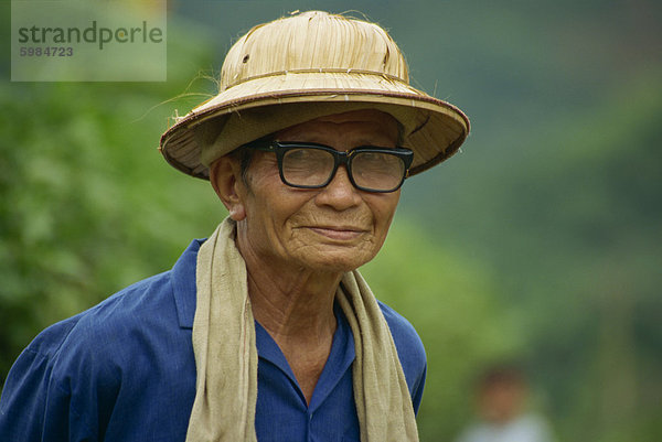 Porträt eines alten Mannes mit Brille und Rafia Hut in Vietnam  Indochina  Südostasien  Asien