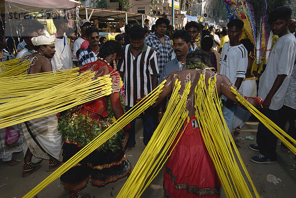 Männer mit Haken durch die Haut auf dem Rücken auf dem jährlichen Hindu-Festival der Thaipusam in den Batu-Höhlen in der Nähe von Kuala Lumpur  Malaysia  Südostasien  Asien