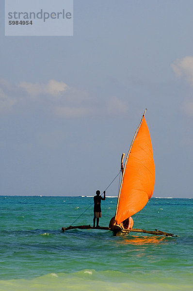 Eine traditionelle Holzdau mit einer orange Segel  Paje  Zanzibar  Tansania  Ostafrika  Afrika