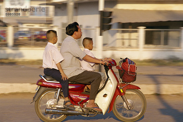 Vater und zwei Söhne auf einem Motorrad in der Innenstadt der Stadt Vientiane  Laos  Indochina  Südostasien  Asien